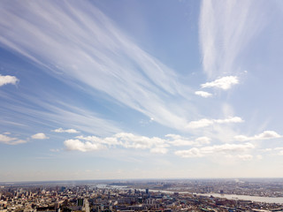 Obraz na płótnie Canvas Clouds in the blue sky wih buildings under them at Novosibirsk, Russia. Streets and skyline.