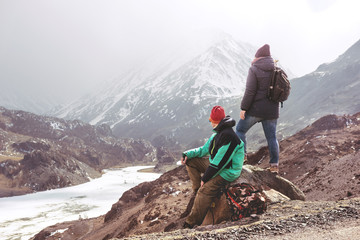 Two tourists at view point against mountains