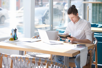 Charming and thoughtful man, an outsourcing employee of large business center, opens his laptop...