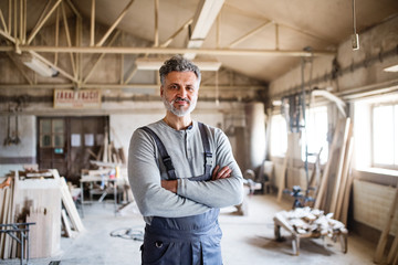 Portrait of a man worker in the carpentry workshop.