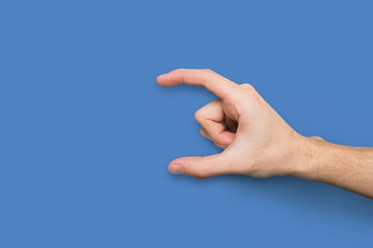Male hand measuring something on blue background
