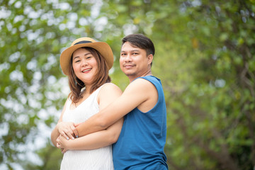 Obraz premium Happy chubby lover couple are posting on the rock.