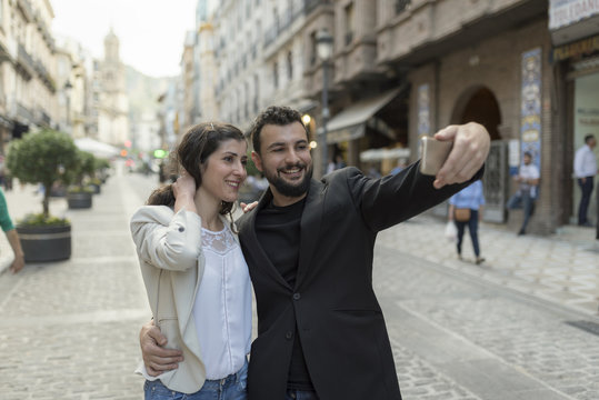 Mid adult couple taking self portrait in european city