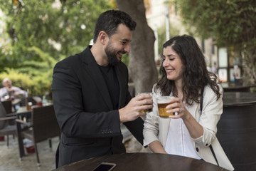 Couple in bar celebratibng anniversary and drinking beer and valentines