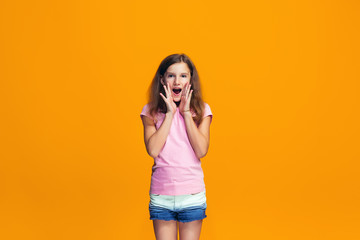 Isolated on yellow young casual teen girl shouting at studio