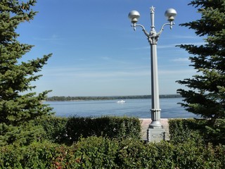 Фонарный столб со звездой на вершине среди зелени деревьев © fengmolong