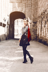 Fototapeta na wymiar beautiful blonde is standing on city streets. stylish and sexually dressed. skirt. red lipstick on lips