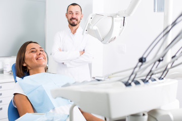 Young female is sitting satisfied after treatment in dental office