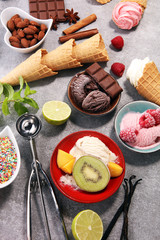 Vanilla frozen yogurt or soft ice cream and waffle cone and fruits.