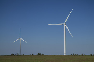 Wind energy turbines on sunset sky background, Energy generator nature friendly. Spring field.