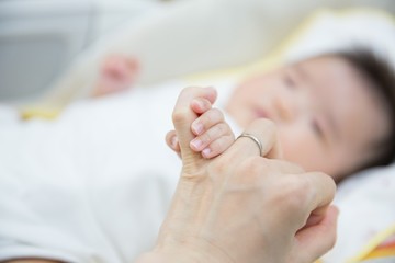 母親の指を握る赤ちゃん