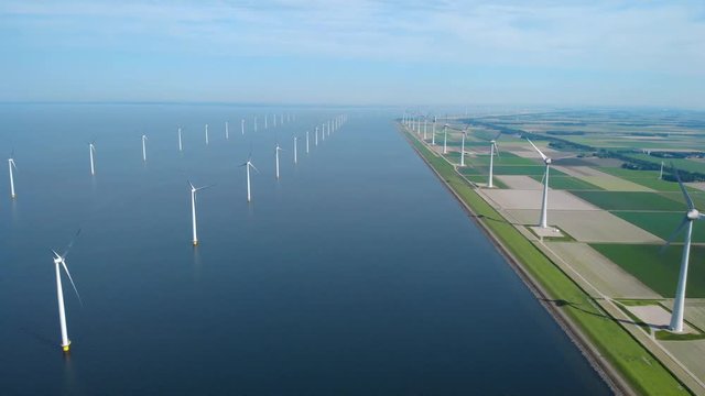 Aerial drone shot of huge electricity windmills in the sea, Windmill farm seen from the sky in the ocean offshore