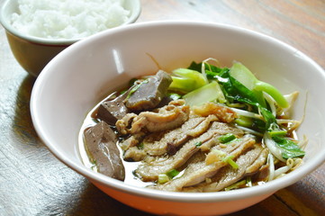 boiled duck meat and blood in brown Chinese herb soup on bowl eat couple with rice