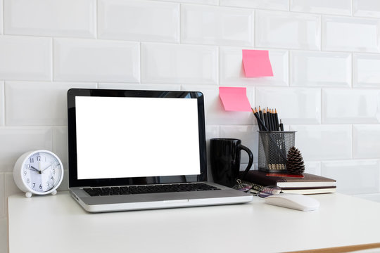 Mockup blank screen laptop on desk. Workspace with laptop and office supplies.
