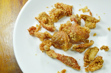 deep fried chicken skin with salt and pepper on white plate