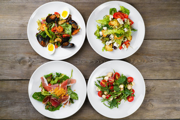 Assortment of fresh vegetable salads flat lay. Top view on vegetarian buffet with tasty side dish...