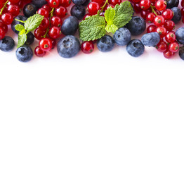Mix berries on a white background. Berries and fruits with copy space for text. Ripe blueberries, red and currants on white background. Top view. 