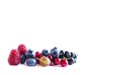 Fruits and berries isolated on white background. Ripe currants, blueberries, raspberries and gooseberries. Sweet and juicy fruits with copy space for text. Top view.