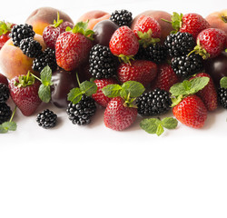 Obraz premium Ripe blackberries, strawberries, plums and peaches on white background. Top view. Background berries.