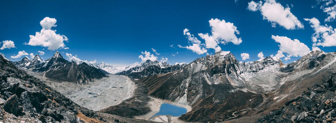 Amazing panoramic view the mighty Himalayas and peaceful Gokyo Lake on the blue cloudy sky background. Everest Base Camp trek in the Sagarmatha National Park in the north-eastern Nepal.