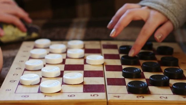 Hands move checkers on the Board