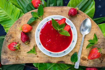 Fresh raw strawberry mint dessert for breakfast. Fruit yoghurt or smoothie on wooden board. Fruit jam mixed with blender. Raw vegan vegetarian healthy food