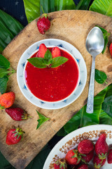 Fresh raw strawberry mint dessert for breakfast. Fruit yoghurt or smoothie on wooden board. Fruit jam mixed with blender. Raw vegan vegetarian healthy food