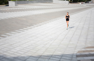 Obraz premium Young woman running in city copy space