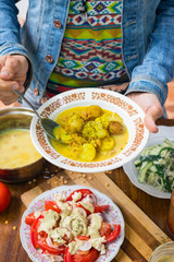 Woman hands holds peas creamy lentil soup puree with new backed potatoes with olive oil, turmeric powder, spices and herbs. Mixed with blender. Raw vegan vegetarian healthy food on lunch or dinner