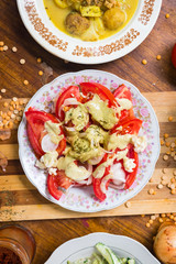 Fresh tomatoes salad with walnuts sauce and onion rings dressing. Spices and herbs, olive oil added. Raw vegan vegetarian healthy food