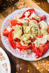 Fresh tomatoes salad with walnuts sauce and onion rings dressing. Spices and herbs, olive oil added. Raw vegan vegetarian healthy food
