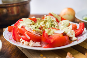 Fresh tomatoes salad with walnuts sauce and onion rings dressing. Spices and herbs, olive oil added. Raw vegan vegetarian healthy food