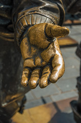 Close-up of open hand in bronze sculpture on the Rembrandt Square in a sunny day at Amsterdam. The city is famous for its huge cultural activity, graceful canals and bridges. Northern Netherlands.