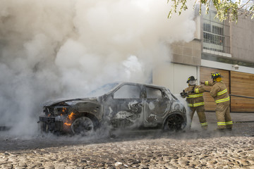 Fototapeta premium Firefighters extinguish a burning car