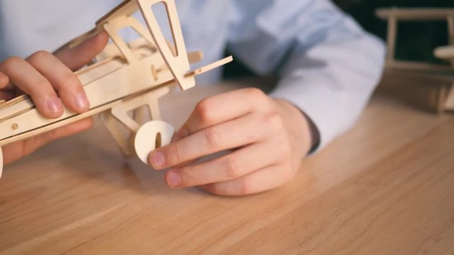 The boy at home collects a wooden plane. The concept of dream and childhood
