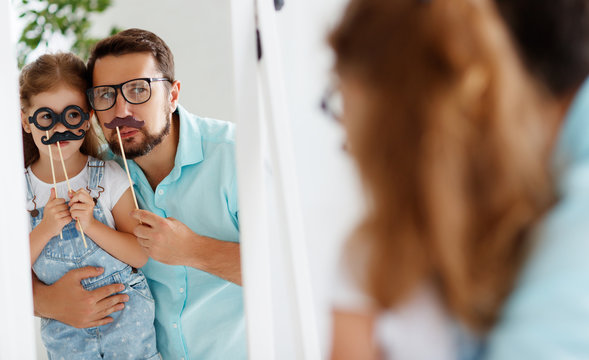 Happy Father's Day! Funny Dad And Daughter With Mustache Fooling Near Mirror