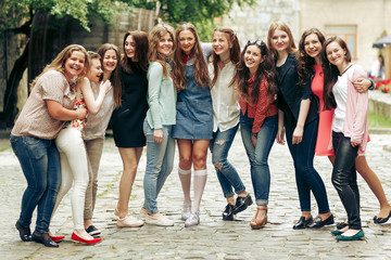 Obraz na płótnie Canvas Group of happy stylish women having fun on background of old european city street, travel or celebrating friendship concept, moments of happiness