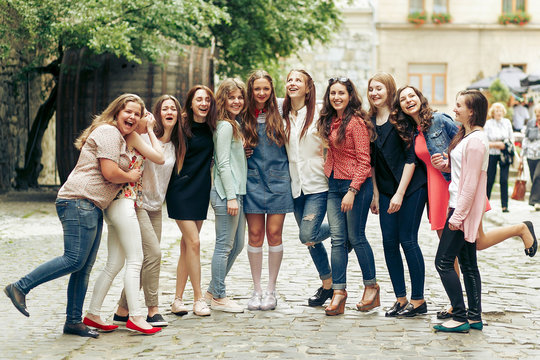 Group of happy stylish women having fun on background of old european city street, travel or celebrating friendship concept, moments of happiness