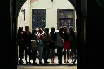 Fototapeta premium young happy women looking at old european city street, stylish hipster girls, moments of happiness, friendship concept, view from back.