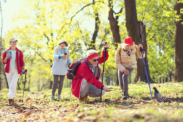 Come here. Cheerful aged man smiling and amusing with a pigeon while hiking