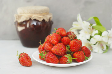 Strawberry Jam and Fresh Strawberries Textured Cement Grau Background and Jam Jar