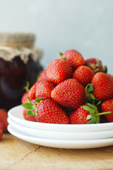 Strawberry Jam and Fresh Strawberries Textured Cement Gray Background and Jam Jar