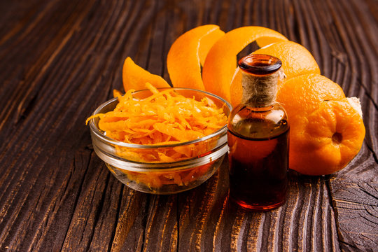 orange essential oil on a wooden background