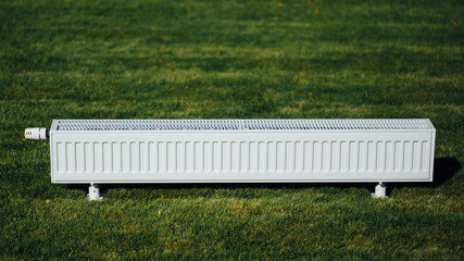 radiator on green lawn, ecological heating concept