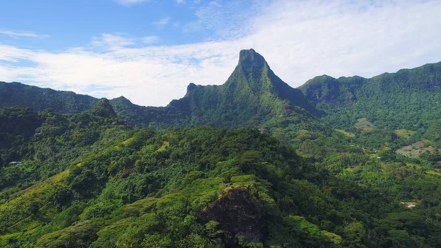 Aerial view of panorama of tropical paradise of Moorea island, Mount Mouaputa on horizon, lush green jungle, scenic hills, mountains and valleys - South Pacific Ocean, French Polynesia landscape