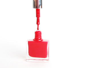 Fototapeta premium Nail Red Polish Flowing from the Bottle on White Background Beauty Fashion