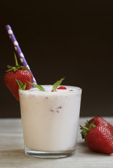 Milk Cocktail Shake Drink with Srawberry. homemade Fruit Milkshake with Straw in Glass. Rustic Gray wooden Background.