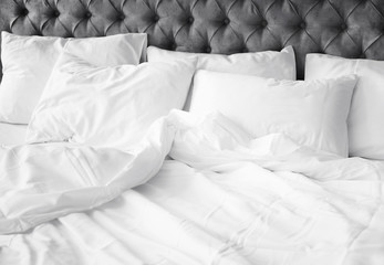 Comfortable bed with white linen at home