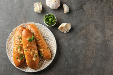 Plate with delicious homemade garlic bread on table