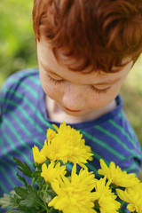 So beautiful. Nice pleasant boy looking at the flowers while being in a great mood